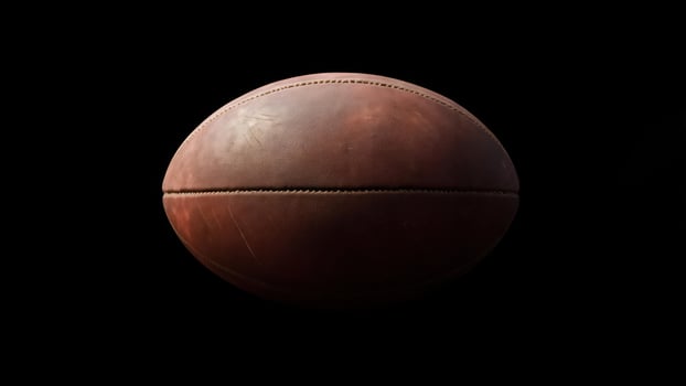 Aged leather ball against black background photo