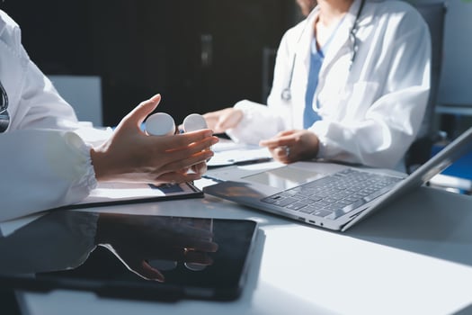 A doctor is holding a stethoscope and a laptop photo