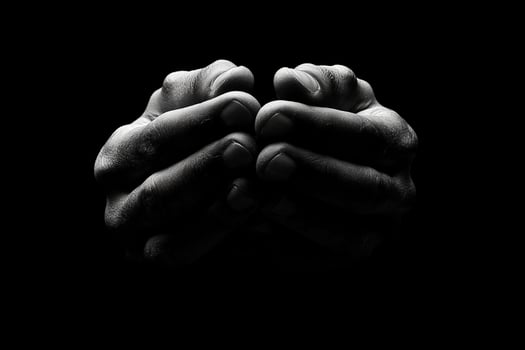 Hands praying in black and white photo