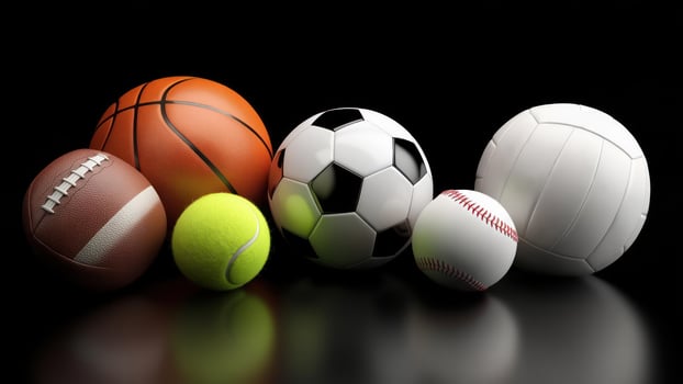 Assorted sports balls on reflective surface photo