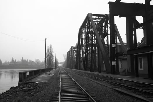 A black and white photo of a railroad bridge