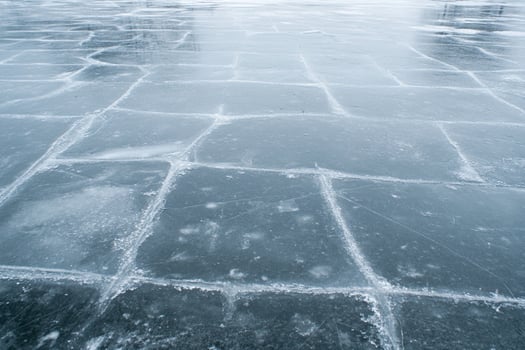 A man on a skateboard is riding down a frozen lake photo