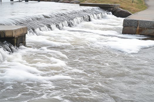 A man is riding a surfboard down a river photo