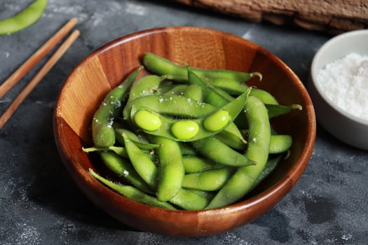 Green soybeans or Edamame in wooden bowl. Healthy snack and side dish in Asian food photo