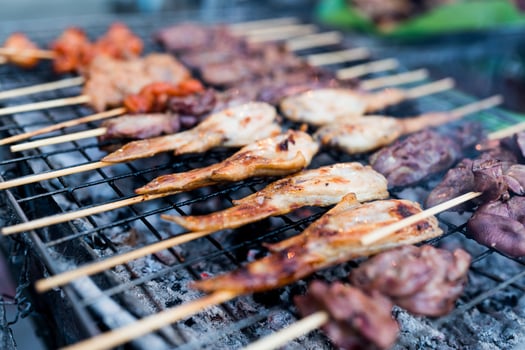 Cooking many roasted skewers on hot grill photo