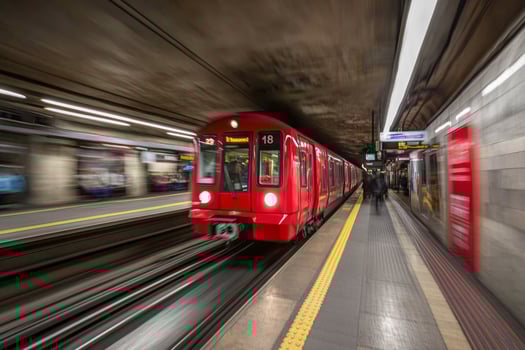 A red train is moving through a subway station photo