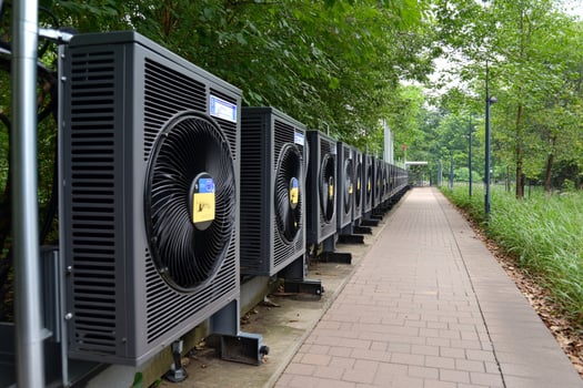 A row of air conditioners on a sidewalk photo