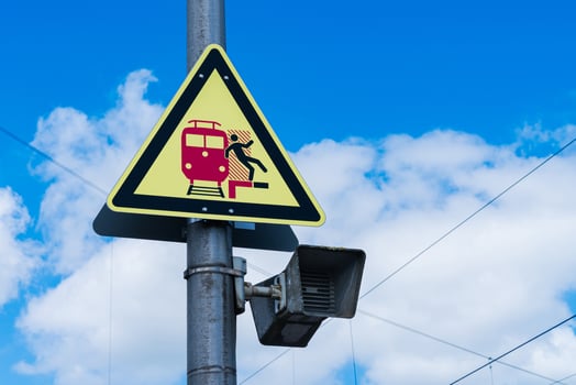 Warning sign indicating train safety measures on a clear day photo