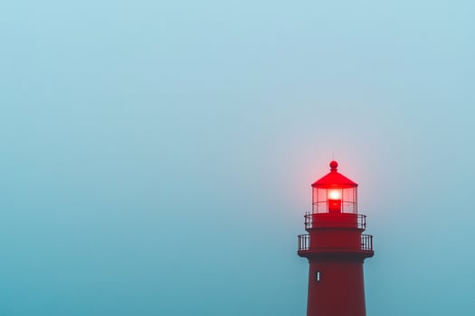 A red lighthouse in the fog photo