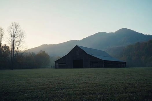 A barn sits in the middle of a field photo