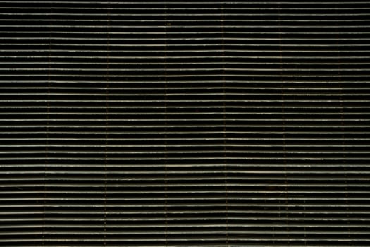 A horizontal woven structure made of narrow strips creates an elegant textile rhythm. photo