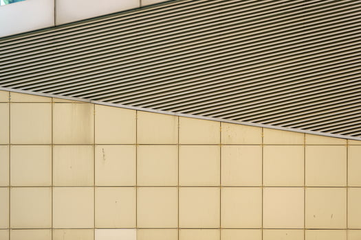 A modern building with a contrasting composition of diagonal lines and square panels showcases architectural rigor and graphic appeal. photo