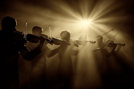 Silhouettes of musicians playing violin in the dark photo