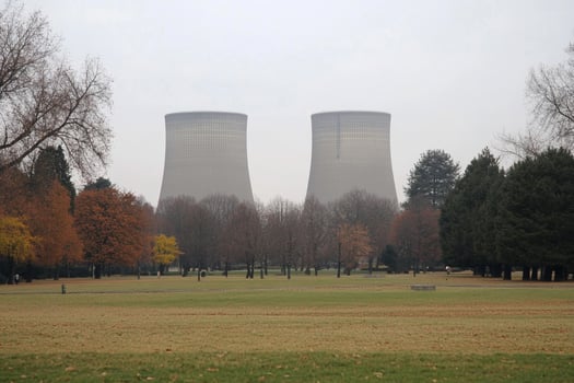 Two cooling towers in a park with trees and grass photo