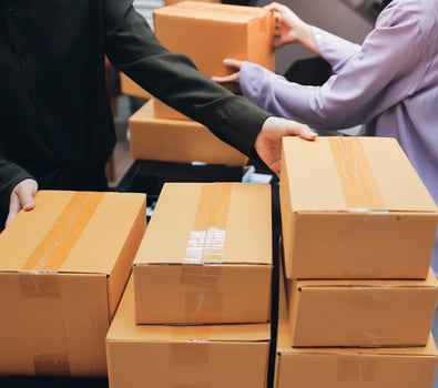 A man and woman are holding boxes of brown paper photo