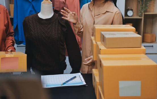 Three women standing around a table with boxes photo
