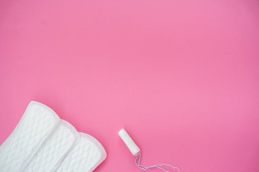 White sanitary pads and a single tampon isolated on pink background. Suitable for topics related to feminine hygiene, menstruation, and women health education. photo