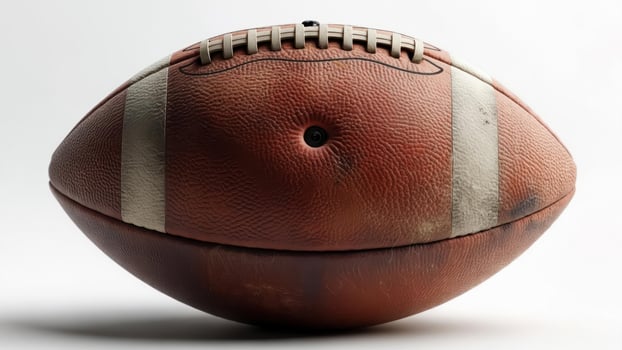 Well-worn, brown leather American football, laces visible photo