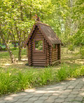 Vintage installation in the park. A small log fairy-tale house, vertical. photo