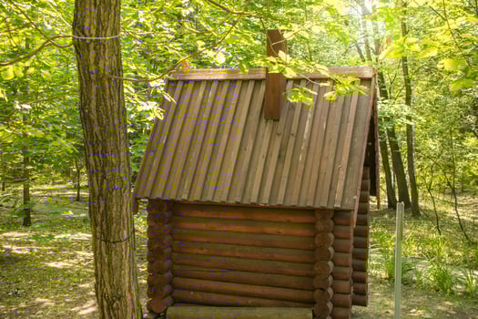 Vintage installation in the park. A small log cabin fairy tale house photo