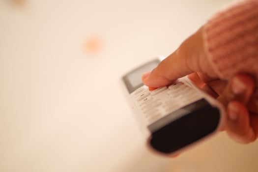 Person using air condition remote cozy indoor setting photo