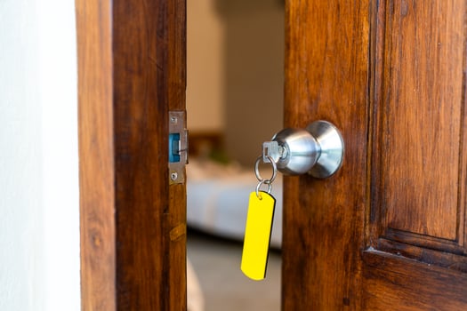Open door to a home with key and keychain. Mortgage, investment, real estate. photo