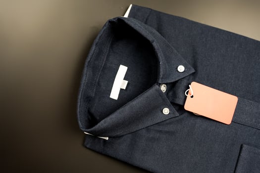 Dark blue classic, neatly folded shirt with a red paper tag photo