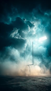 An empty football field with a light shining through the clouds photo