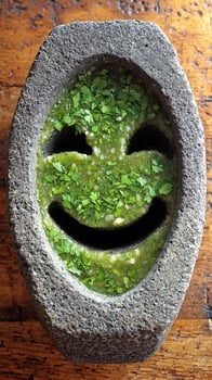 A Smiley Face Formed by Fresh Green Salsa in a Stone Mortar. photo