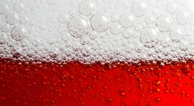 Red beer in a glass close-up, bubbles and beer foam. Design template for advertising Oktoberfest, beer day, advertising fresh drinks with space for text photo