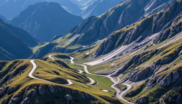 Winding Road Through Majestic Mountain Landscape Under Bright Blue Sky photo