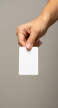 Hand holding a blank white card against a neutral background photo