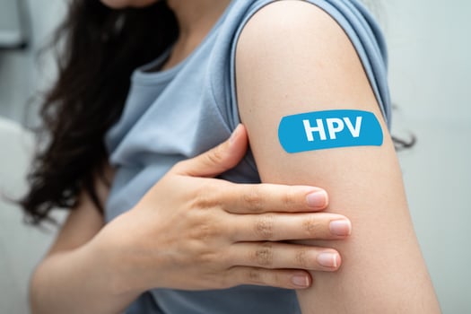 HPV, Human papillomavirus, Asian young woman receiving vaccine with blue bandage. photo