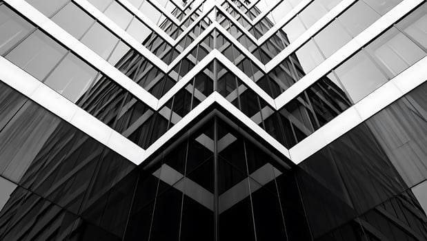 Black and White Architectural Facade of Modern Building with Sharp Angles and Reflective Glass Panels Creating a Striking Geometric Pattern photo