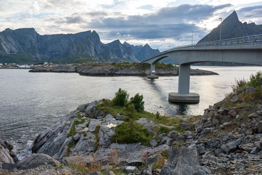 Island town on lake with road bridges and rocky mountains in background, Lofoten Norway photo