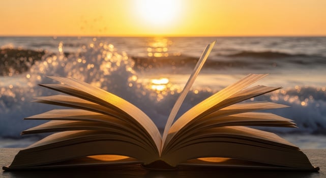 An open book on a table with the sun setting in the background photo