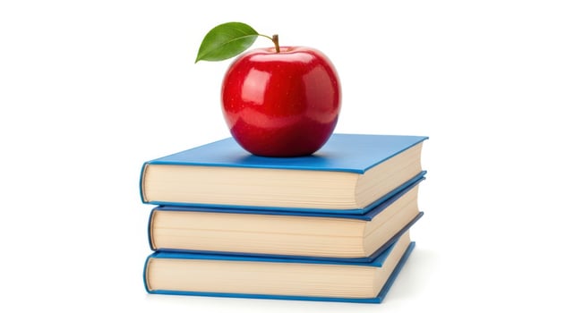 An apple sits on top of three books photo