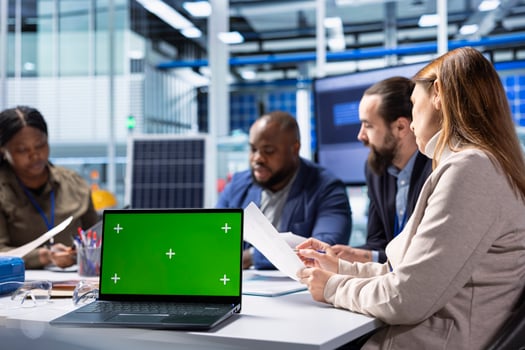 Industrial plant coworkers identifying technical bottlenecks using chroma key notebook. Teamworking businesspeople in factory office analyzing data, reviewing system health metrics with mockup laptop photo