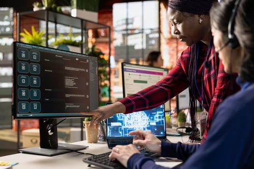Call center manager providing guidance to new recruit on how to use AI chatbot at work. Customer support workplace onboarding specialist teaching new employee to use AI LLM assistant photo