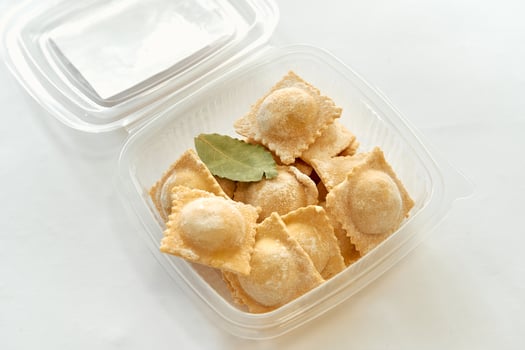 Freshly Made Ravioli with Bay Leaf in a Clear Container Perfect for Cooking and Serving Delicious Italian Pasta Dishes at Home or Special Occasions photo