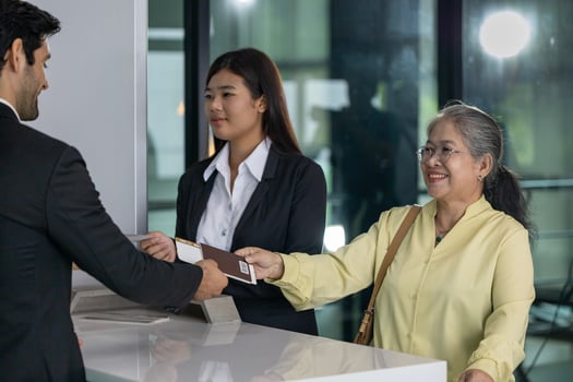 Asian senior passenger showing their boarding pass to the airline ground crew at departure gate into the airplane for final inspection before boarding into plane photo