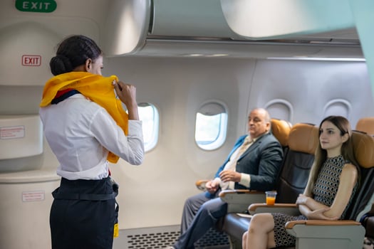 African flight attendant is demonstrating safety procedure using life jacket before taking off in the airplane for cabin crew and airline business photo