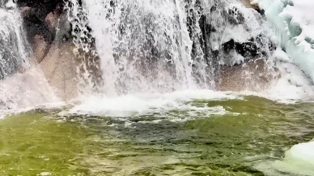 A waterfall is flowing down a rocky stream photo