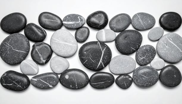 Collection of Smooth Black and Gray Stones with Striped Patterns on White Surface photo
