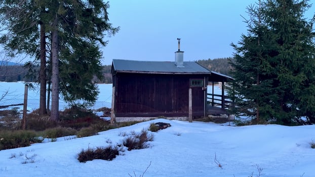 Relaxing at a Tranquil Winter Cabin Located by a Beautiful Lake Surrounded by Snowy Woods photo