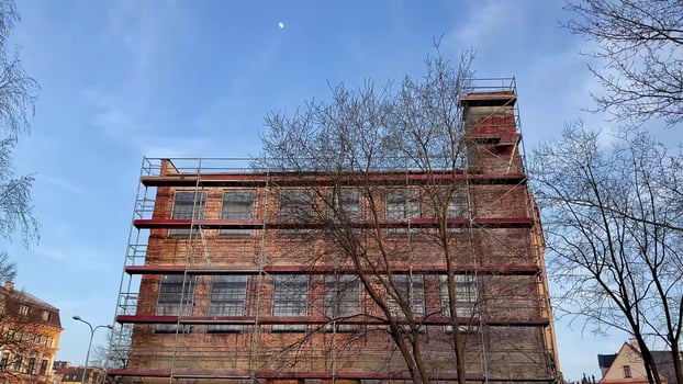 Renovation of the historical brick building under scaffolding has begun, showing urban progress photo