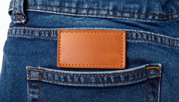 Blue Denim Jeans Back Pocket with Blank Brown Leather Label on White Backdrop photo