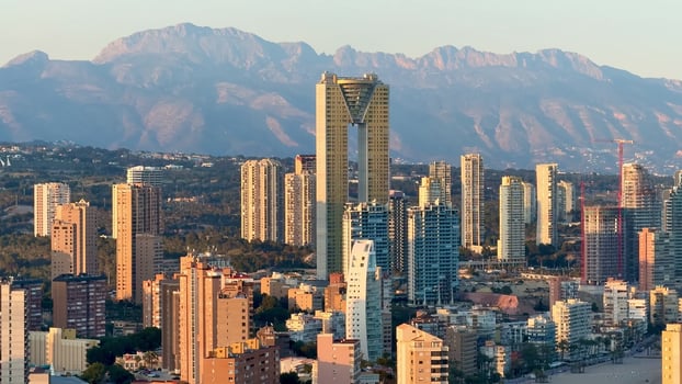 Stunning Aerial View of a Coastal City with Majestic Mountains in the Background photo