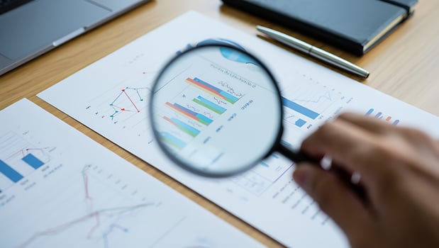 Analyzing Business Data with Magnifying Glass on Charts and Graphs for Strategic Decision Making and Performance Review photo