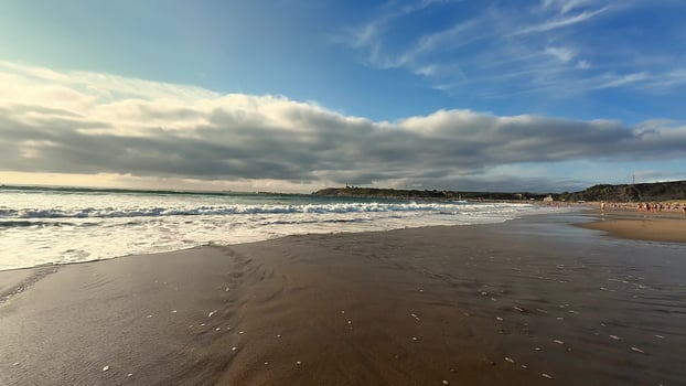 A stunning beach landscape showcasing beautiful waves crashing under the dramatic clouds photo
